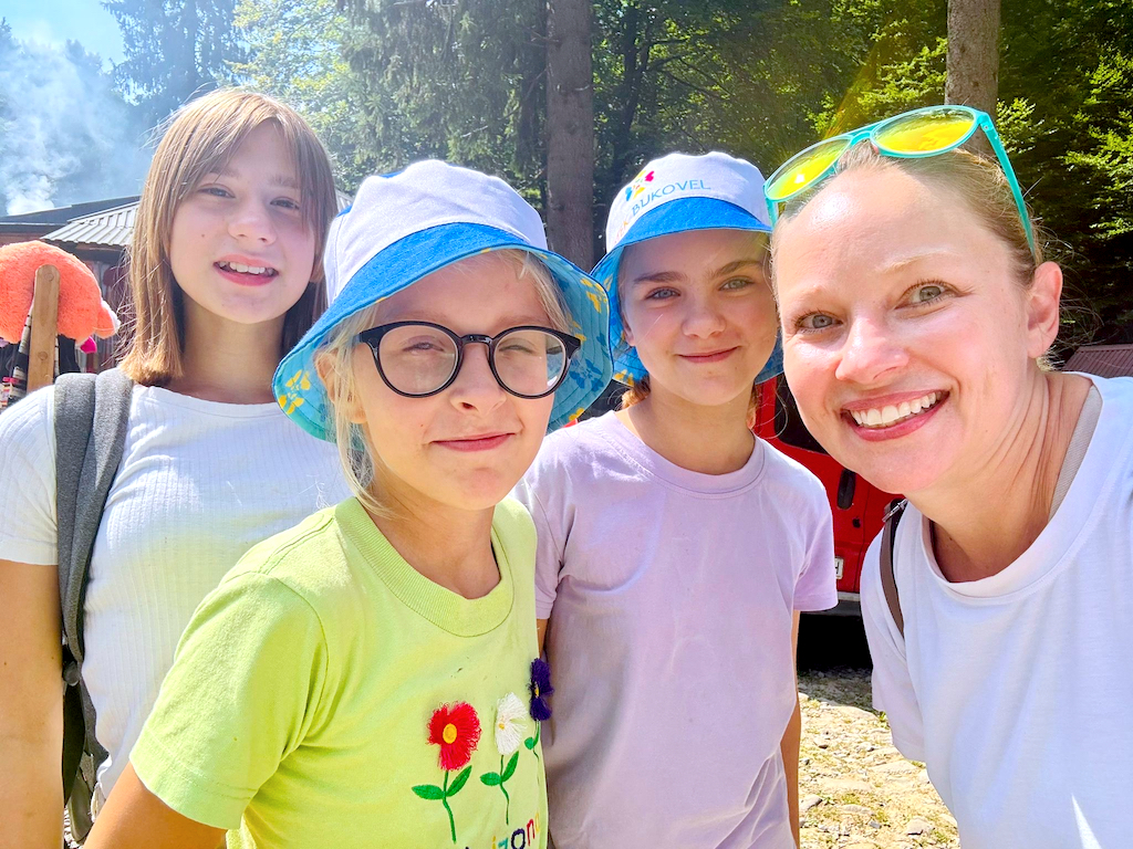 3 young Ukrainian girls with a summer camp volunteer