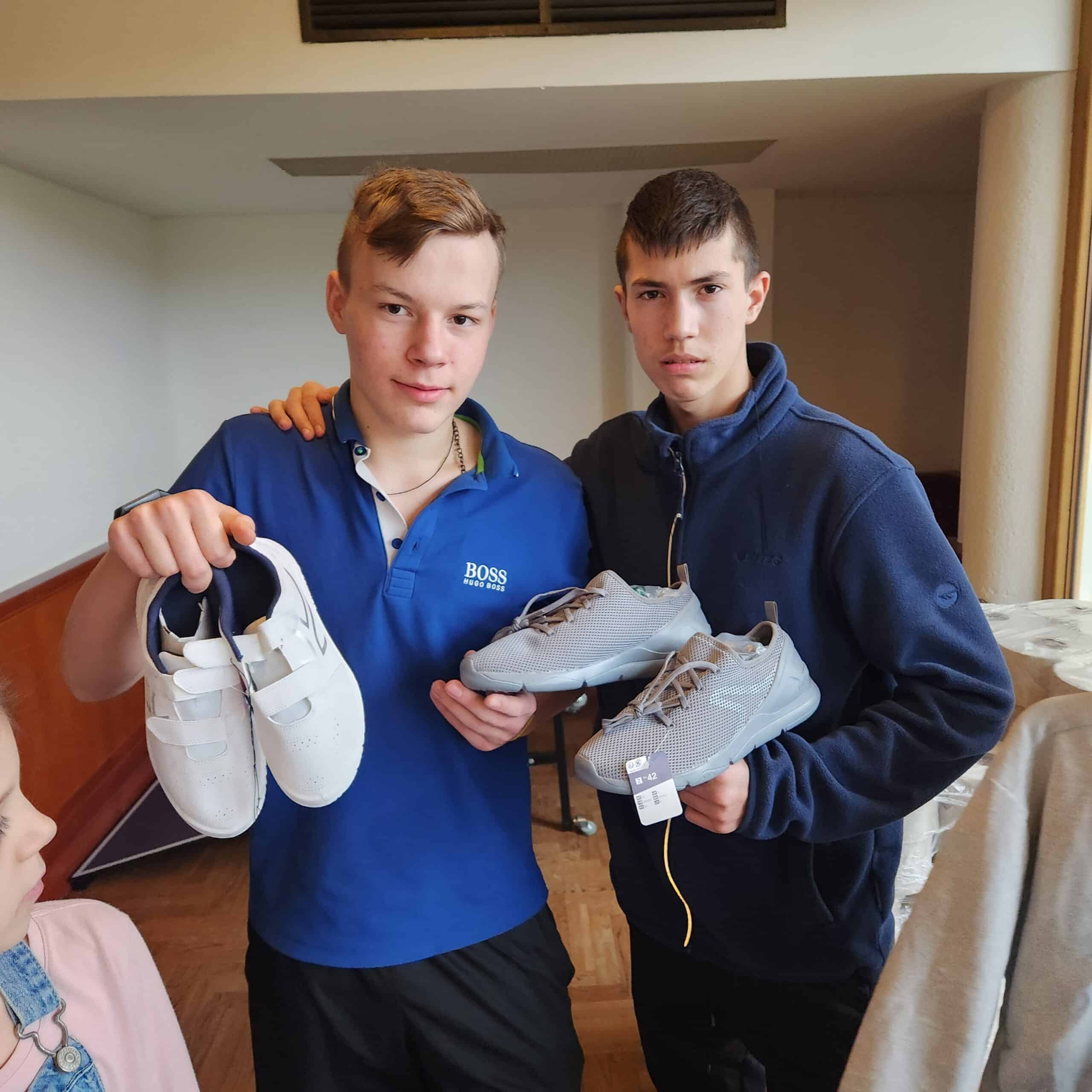 A gentle 6-year-old Ukrainian boy named Oleksandr, looking softly at the camera with a calm, quiet expression. He appears against a simple, brick background.