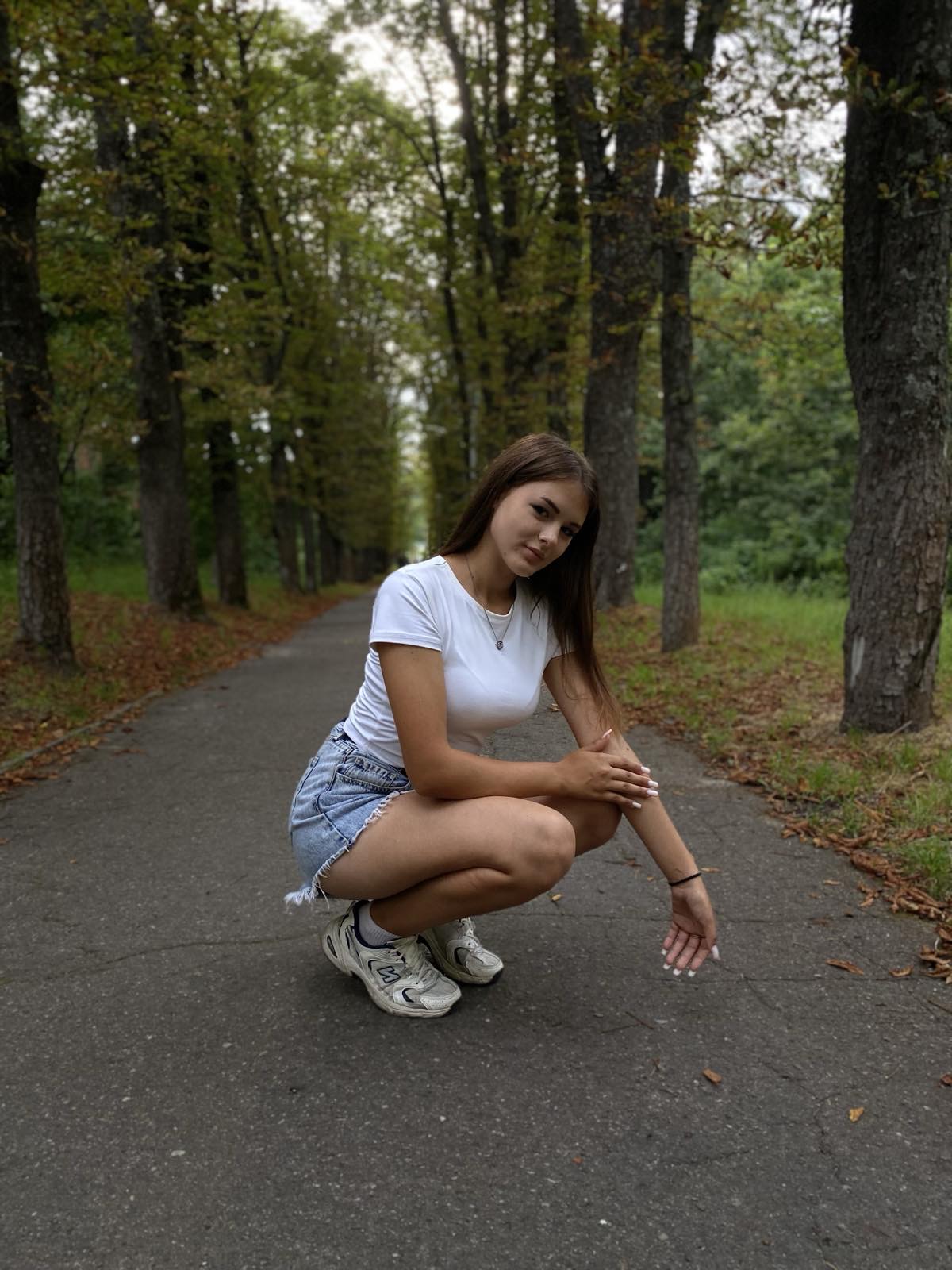 A smiling 16-year-old Ukrainian girl named Daryna, with a confident, creative expression. She is photographed in natural lighting against a simple background.