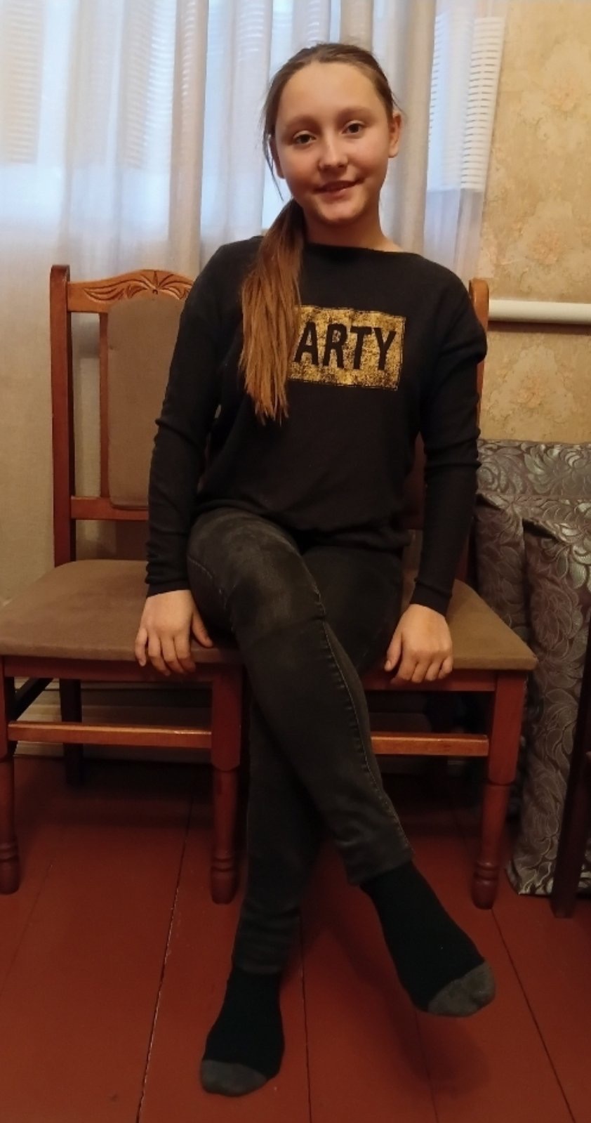 A smiling 12-year-old Ukrainian girl named Inessa, with a warm and friendly expression, photographed in soft, natural lighting against a simple background.
