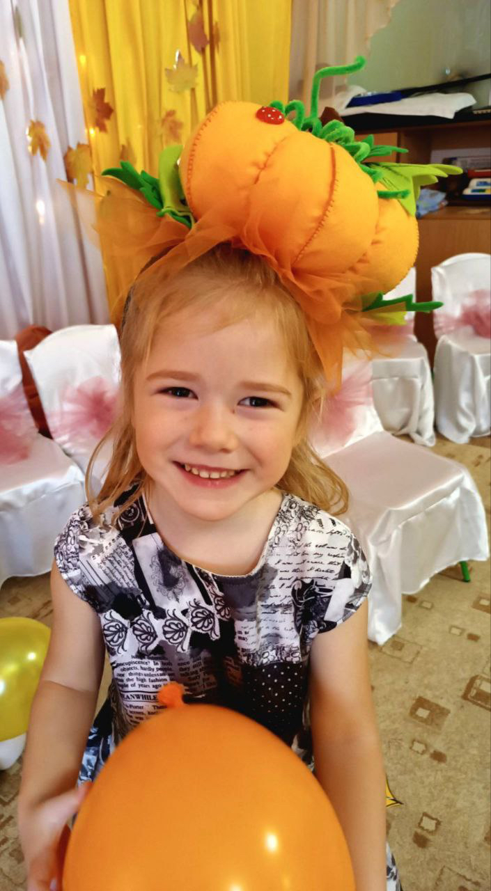 A gentle 3-year-old Ukrainian girl named Milana, looking sweet and friendly, photographed in soft lighting with a calm, tender expression.