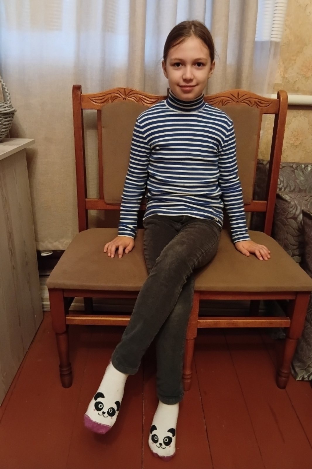 A smiling 7-year-old Ukrainian girl named Oleksandra, with a gentle, friendly expression. She appears in natural lighting against a simple background.