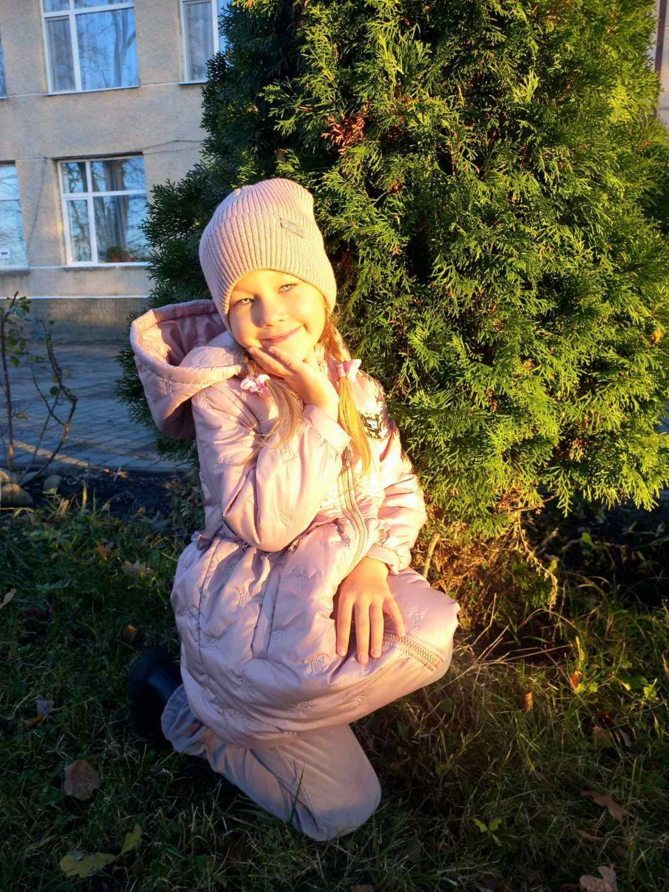 A smiling 5-year-old Ukrainian girl named Viktoriia, with a bright and confident expression, photographed in soft, natural lighting against a simple background.